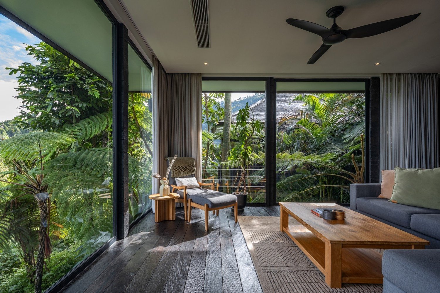 Inside a cabin at Munduk, with floor-to-ceiling windows over the valley